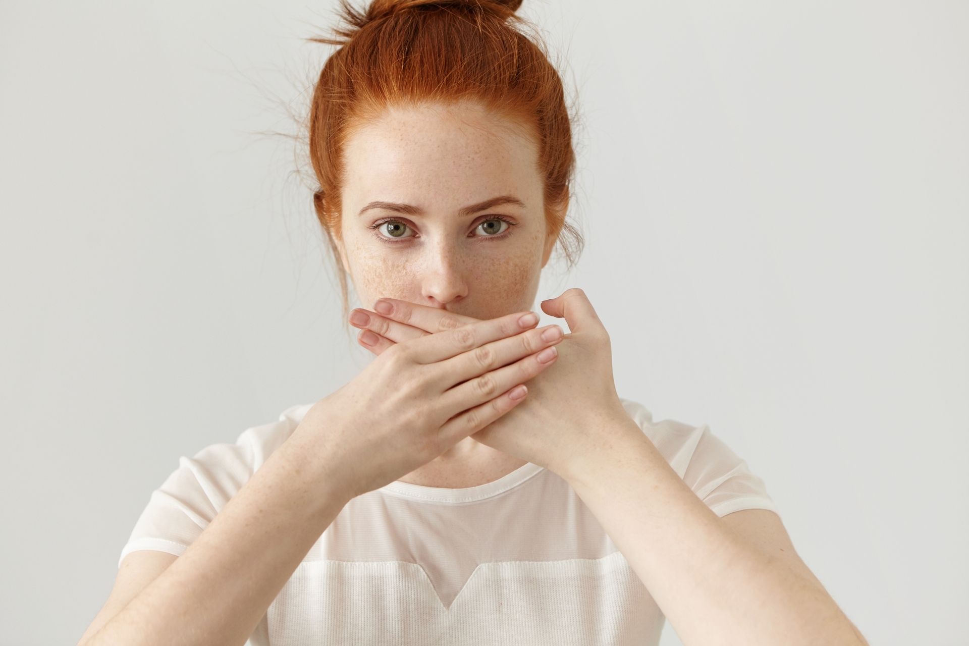 portrait-serious-young-ginger-european-woman-covering-mouth-with-both-hands-keeping-secret-freckled-redhead-female-blouse-doesn-t-want-spread-rumors-some-confidential-information(1)